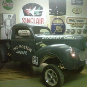 Something about a hot rod sitting next to a pool table